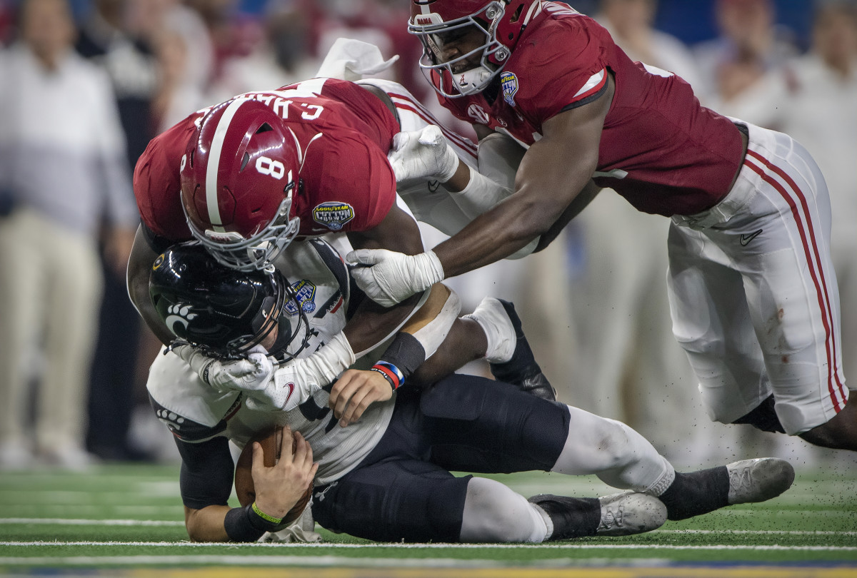 Cincinnati Bearcats quarterback Desmond Ridder (9) is sacked by Alabama Crimson Tide linebacker Christian Harris (8) during the third quarter during the 2021 Cotton Bowl college football CFP national semifinal game at AT&T Stadium.